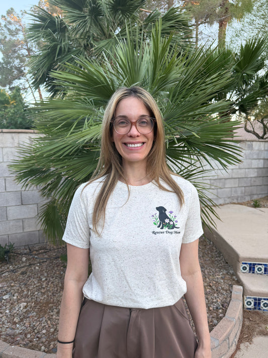 Woman wearing a white t-shirt with a logo in front of a palm tree