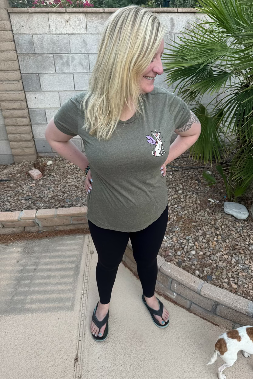 Woman wearing a soft green t-shirt with a fairy dog graphic design on the front.